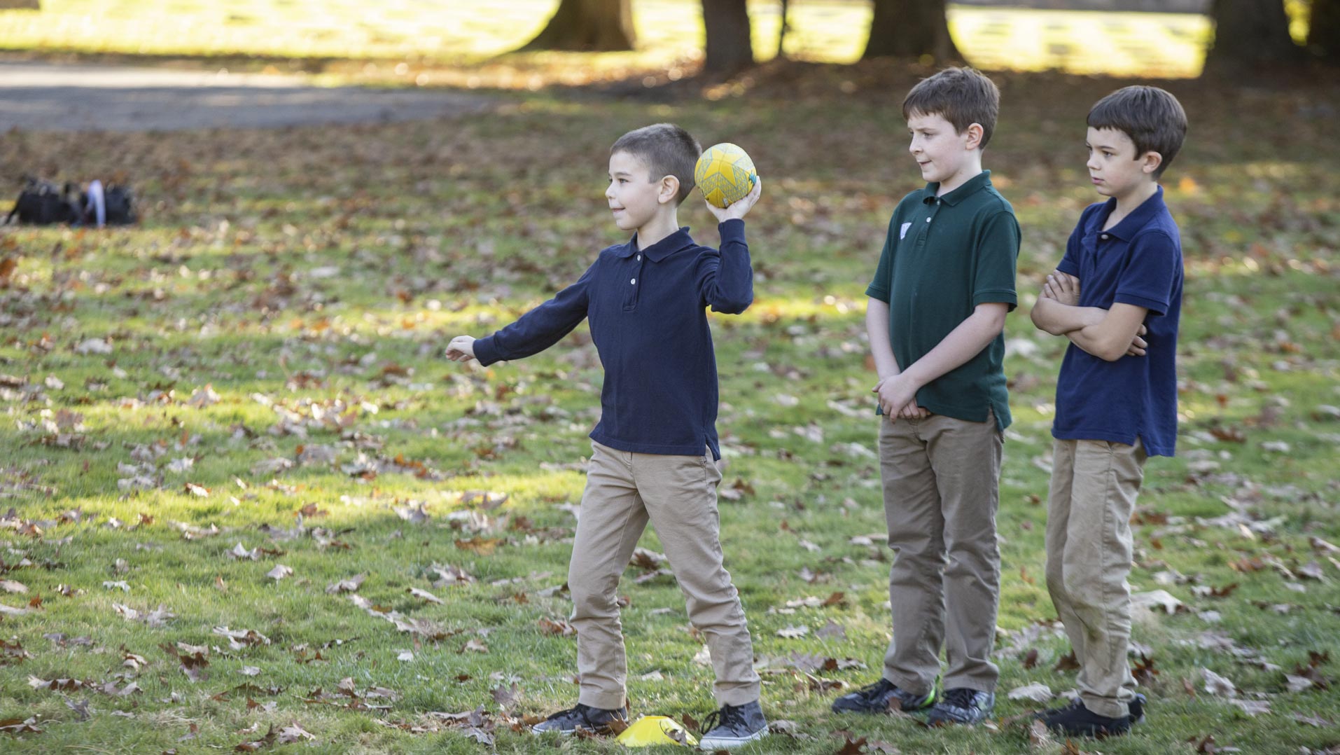 three boys playing outside with a ball